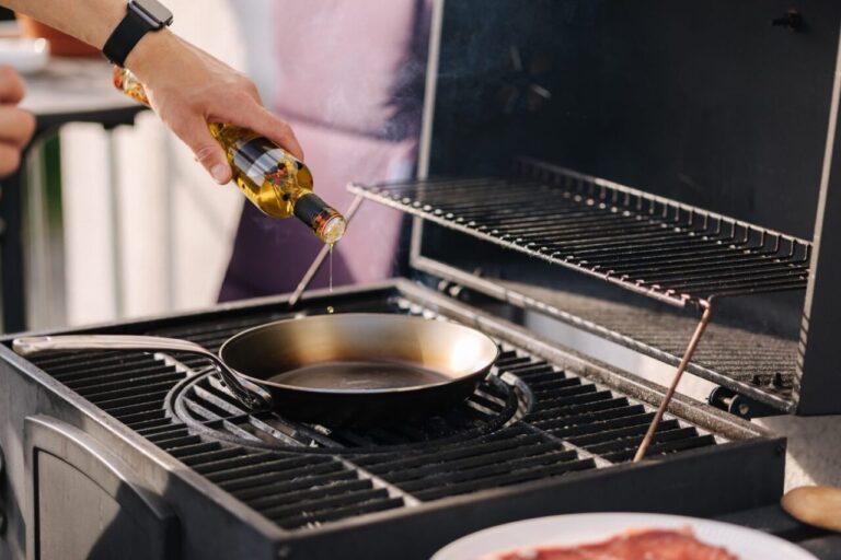 Une personne huile une poêle en acier posée sur une plaque de cuisson pour la culotter.